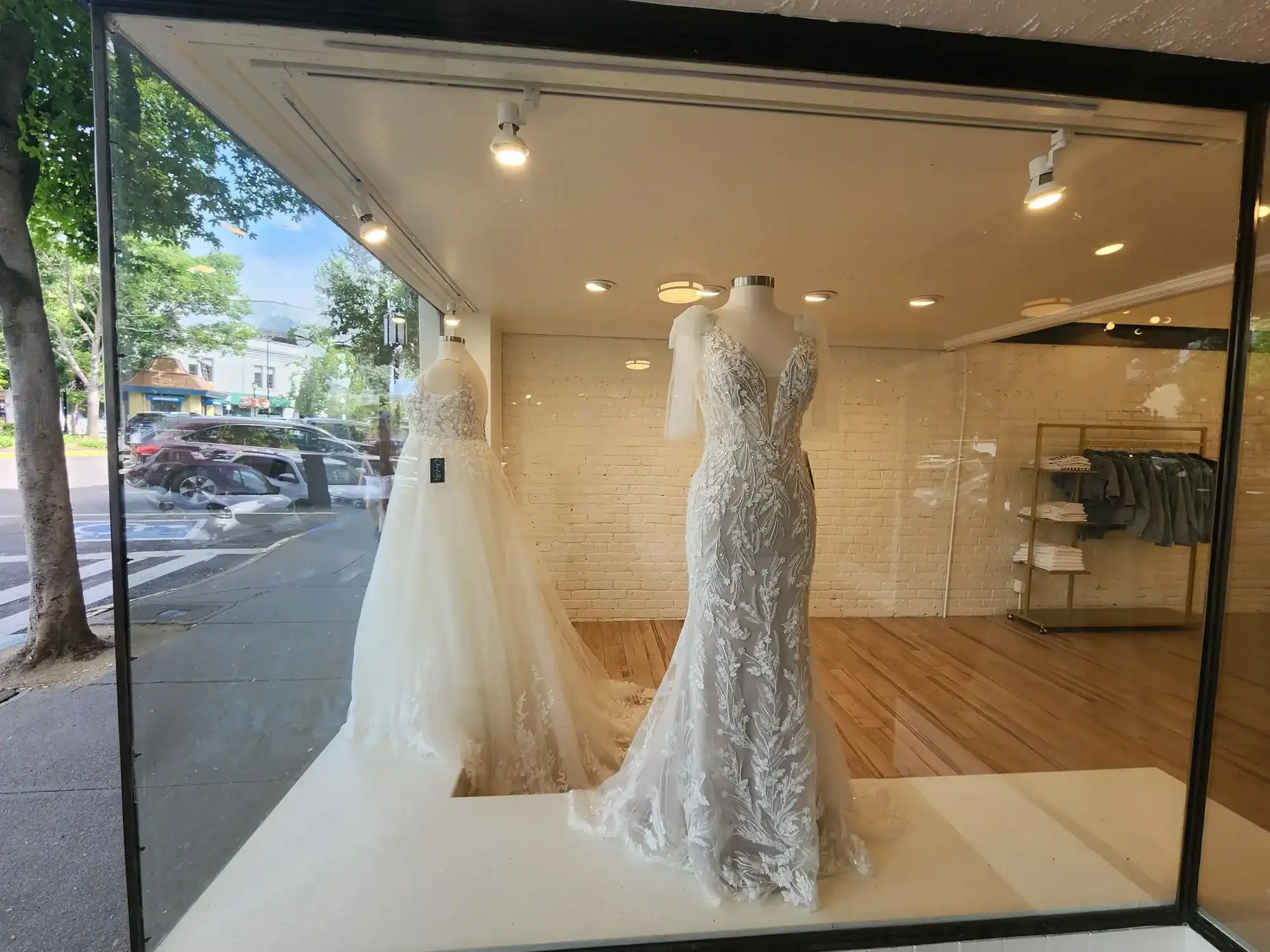 20230613_160015 Bridal boutique window display featuring two white wedding gowns on mannequins