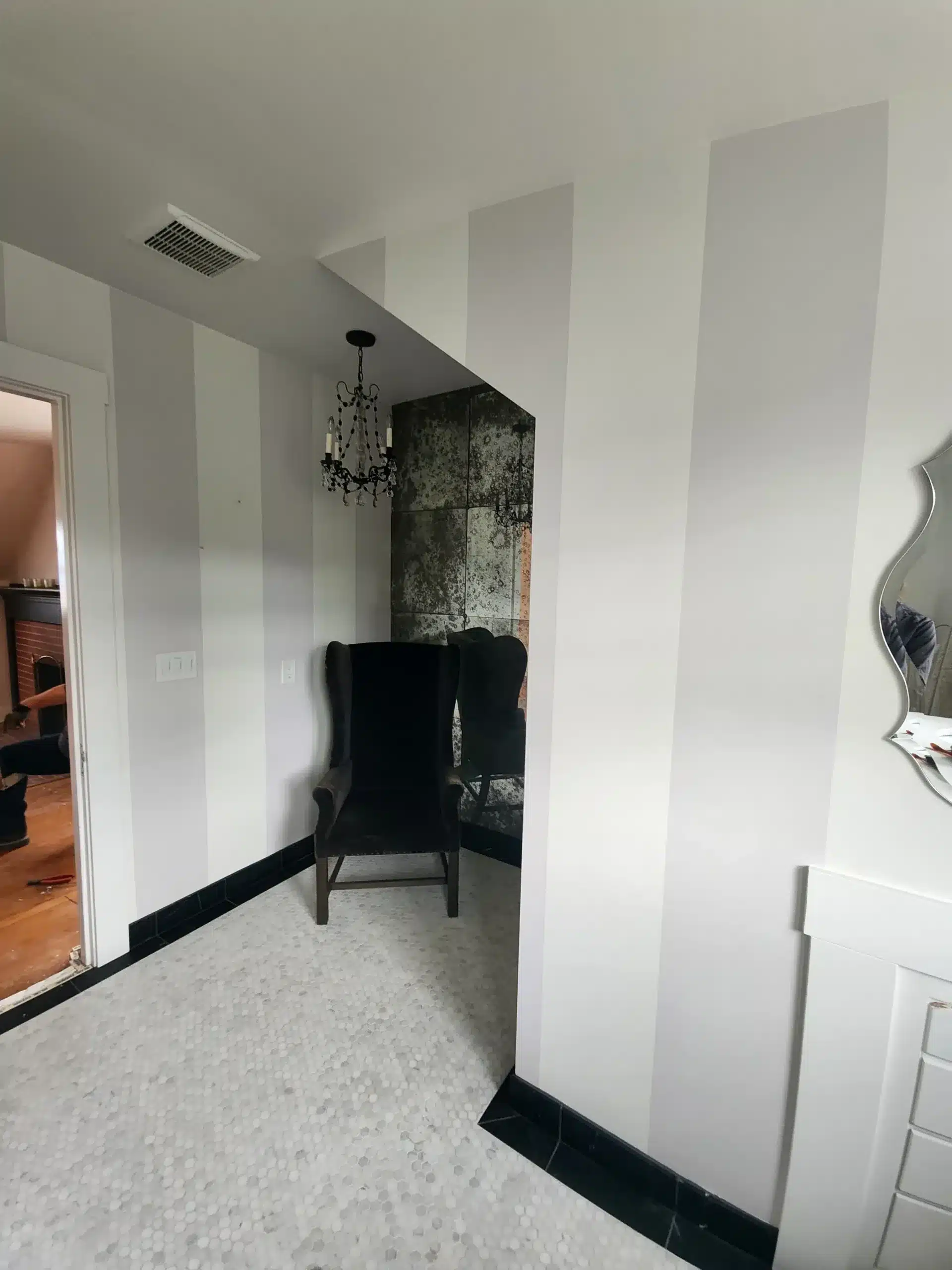 Interior residential painting Painted vertical stripe wall treatment in a dressing room with penny tile floor, black trim, and antique mirror accent wall