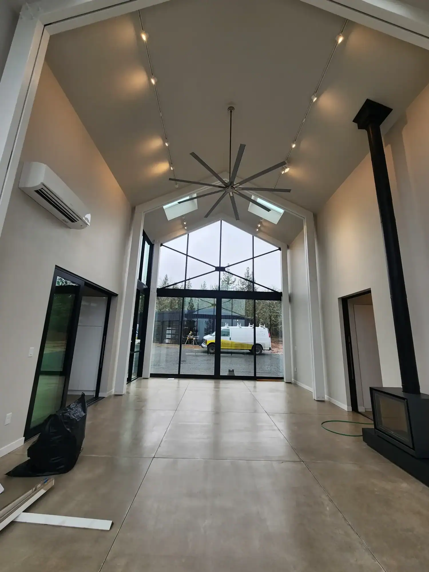Interior residential painting Freshly painted white vaulted great room in a modern new build with floor-to-ceiling black steel windows and polished concrete floors
