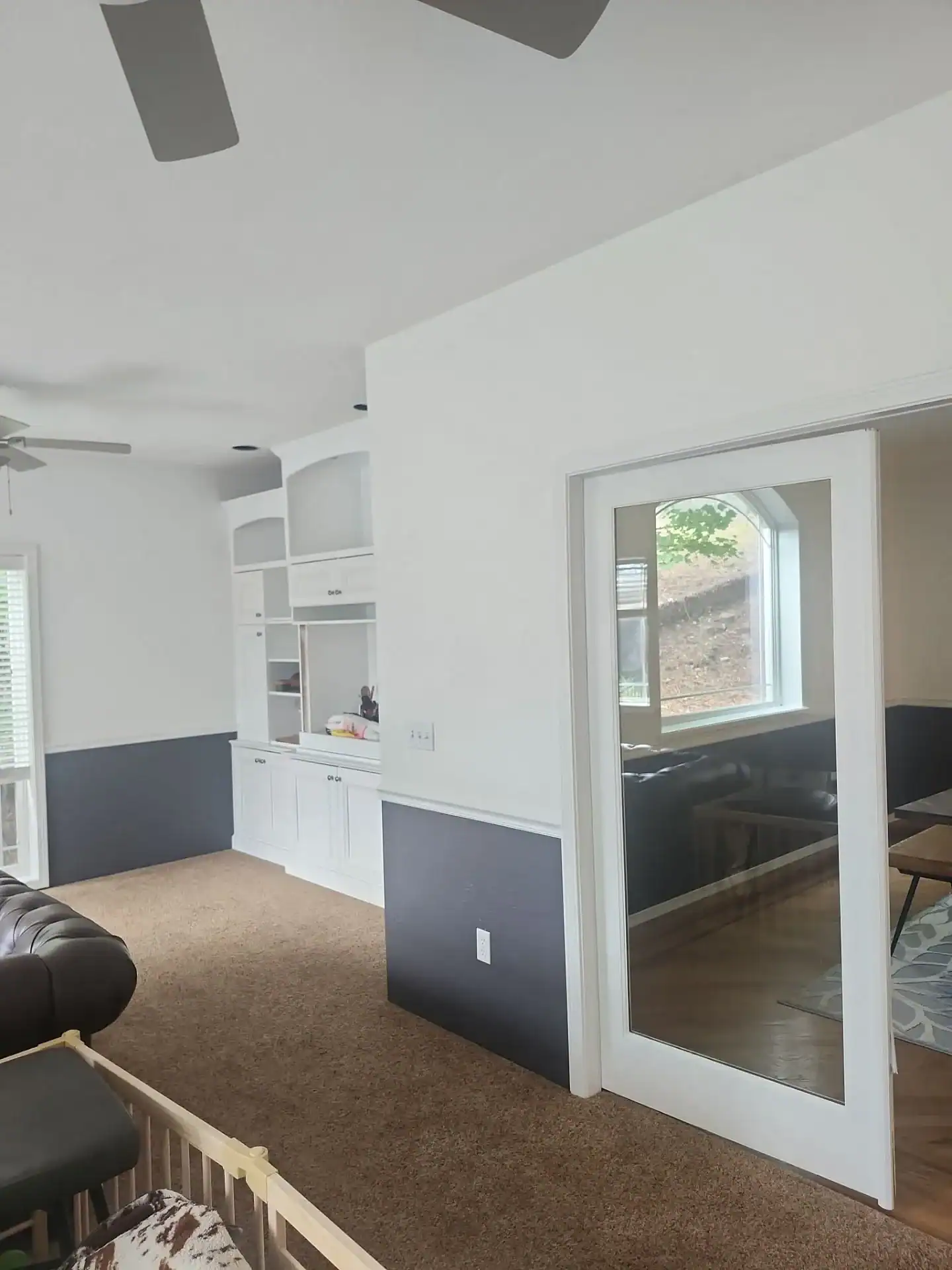 down-net_http20250820-234-vai6r4 (1) Two-tone interior with freshly painted white upper walls, dark gray wainscoting, and white built-in cabinetry