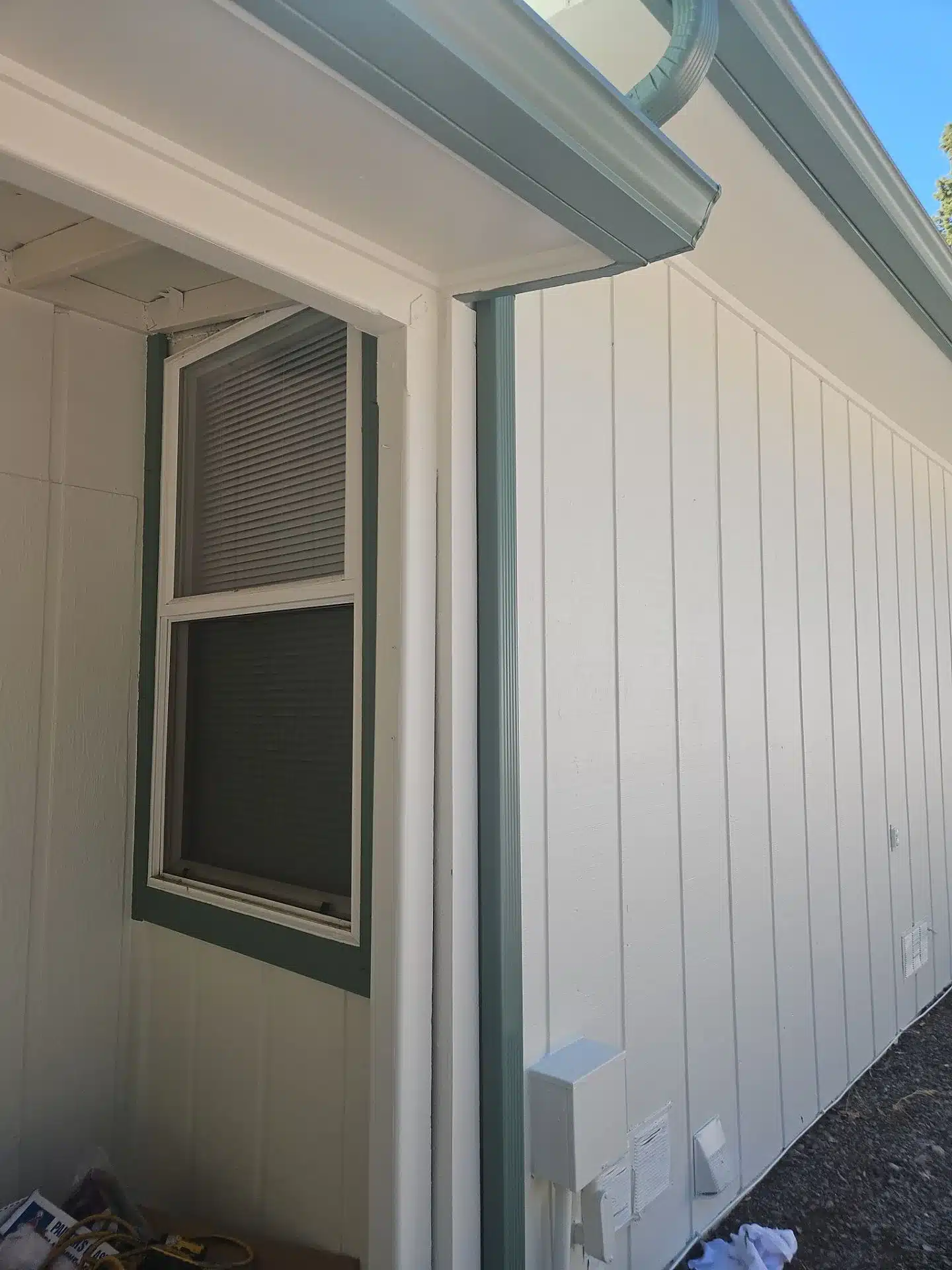Cream Painted Residential Exterior Cream painted residential exterior wall with gray metal trim, dark-framed window, and vertical metal siding in Medford, OR